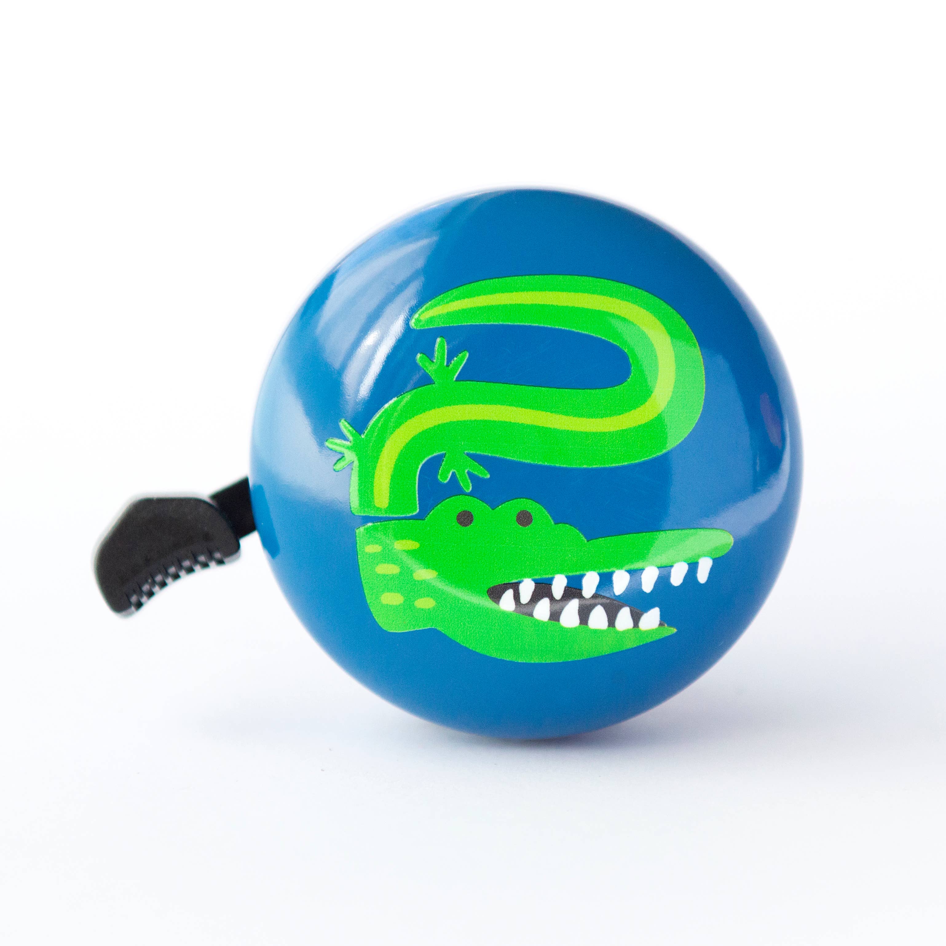 Beep Crocodile Bike & Scooter Bell in deep blue with a crocodile design mounted on a bicycle handlebar.