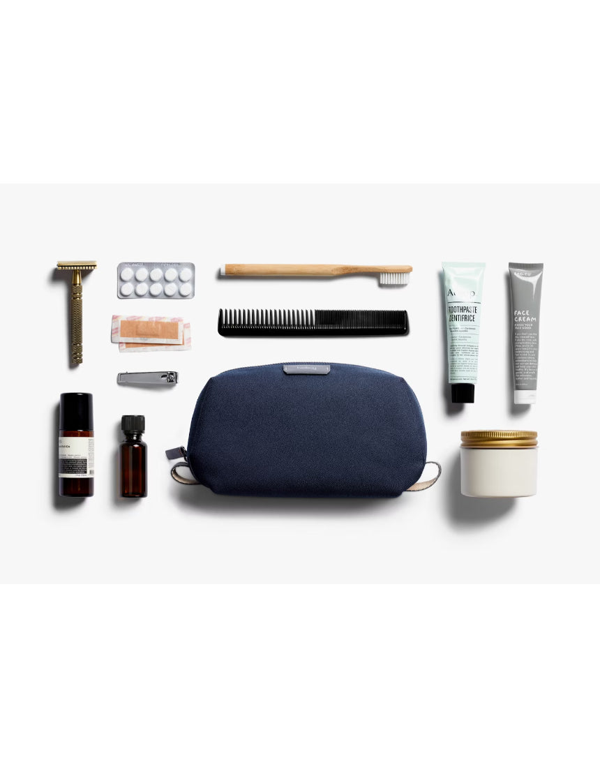Bellroy navy toiletry kit with zipper closure and multiple compartments, designed for organized travel grooming essentials.