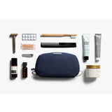 Bellroy navy toiletry kit with zipper closure and multiple compartments, designed for organized travel grooming essentials.