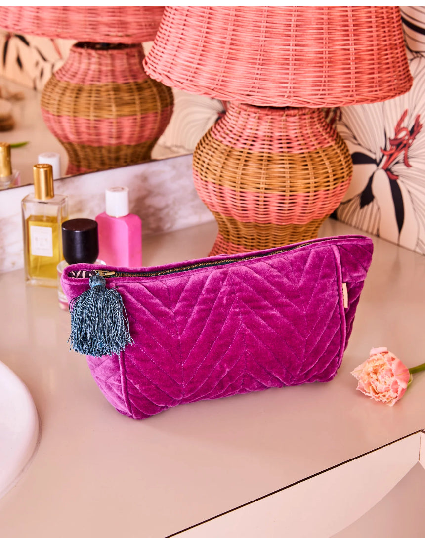 Kip & Co Wild Grape velvet toiletry bag with a soft, plush texture and vibrant purple and pink floral pattern.