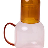 Kip & Co marshmallow and marmalade glass carafe with matching glass set on a wooden surface.
