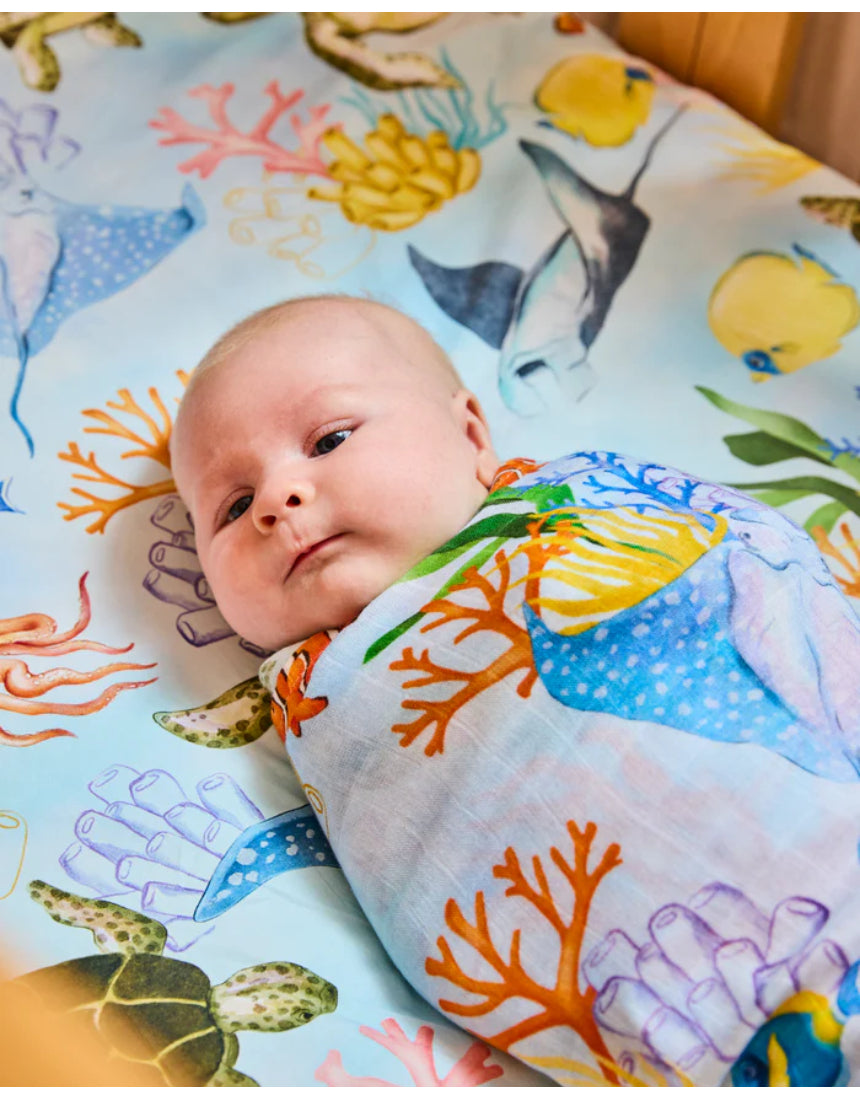 Kip & Co Reef Life bamboo swaddle with vibrant reef and ocean print, soft and lightweight fabric ideal for soothing newborns.
