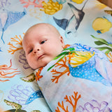 Kip & Co Reef Life bamboo swaddle with vibrant reef and ocean print, soft and lightweight fabric ideal for soothing newborns.