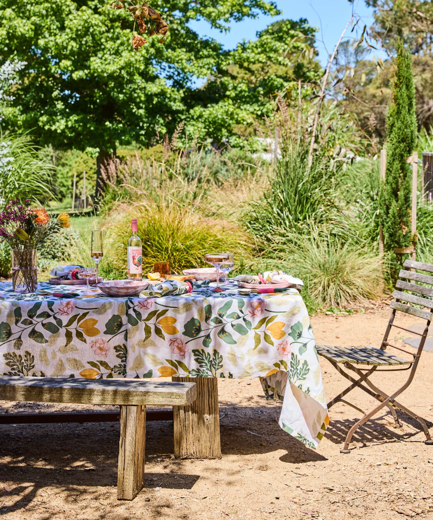 Kip & Co Wander rectangular tablecloth with colorful, patterned fabric draped over a dining table.
