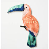 Jones & Co Canopy Toucan Peach wall art featuring a colorful toucan perched among tropical foliage on a peach background.