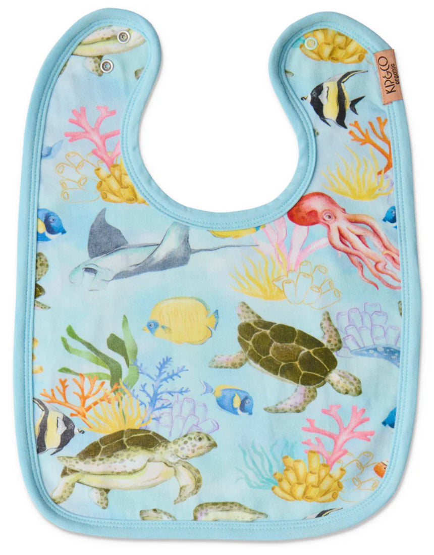 Kip & Co Reef Life cotton baby bib with colorful ocean-inspired print and adjustable neck closure.