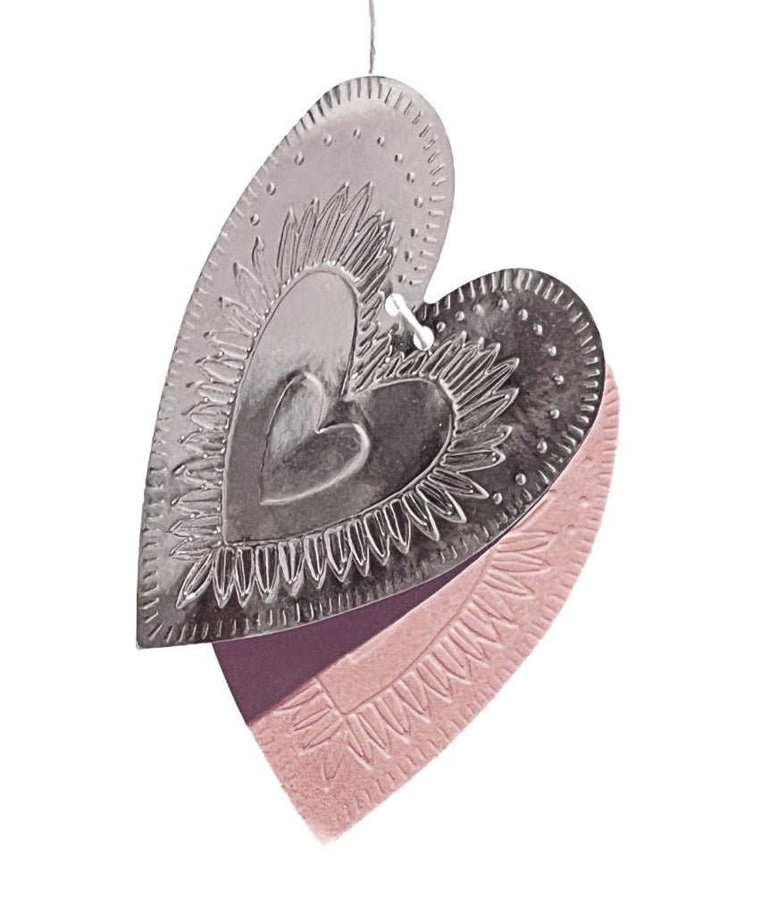 Reversible faux-tin heart bunting in light dusty pink by THE LITTLE PRESS, hanging with fabric and faux-tin heart shapes.