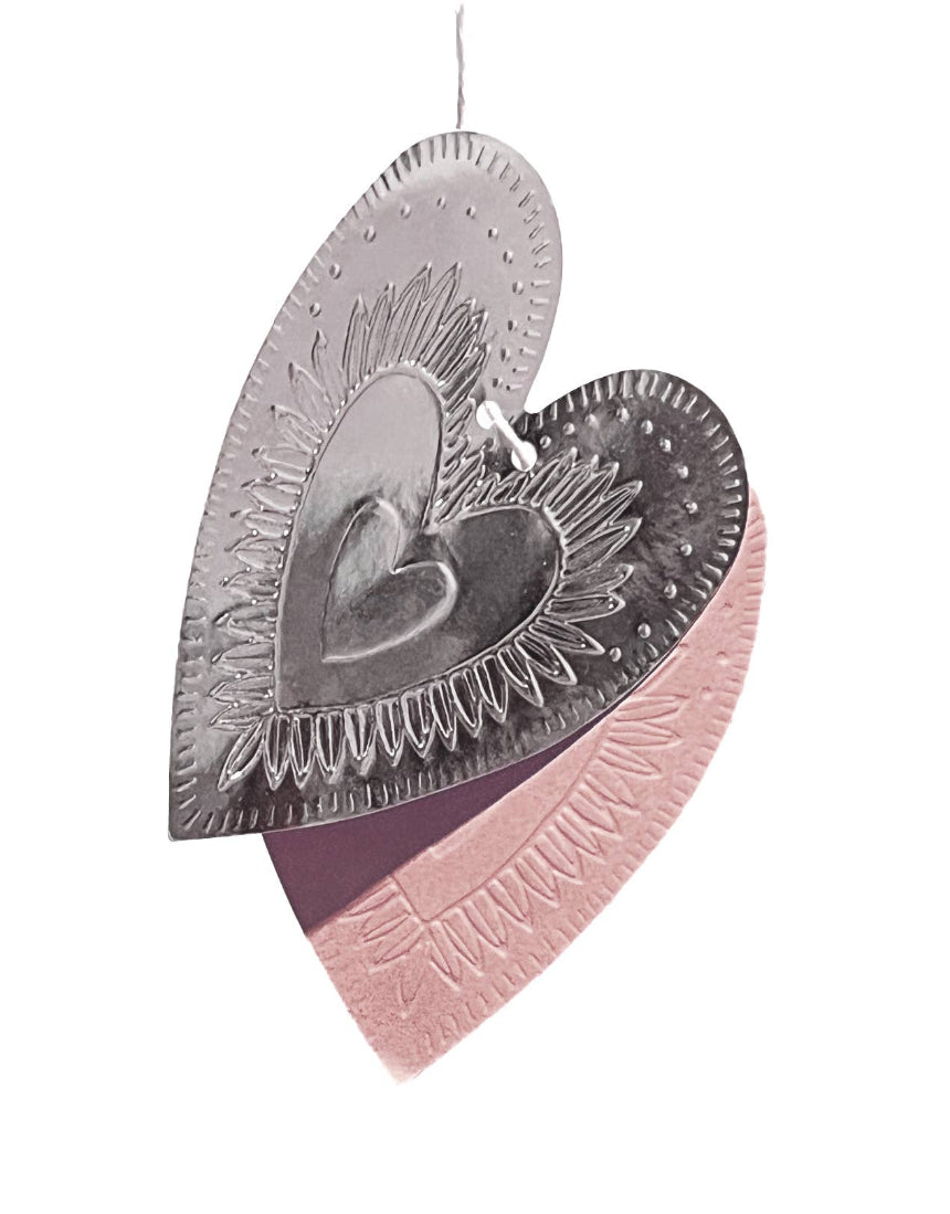 Reversible faux-tin heart bunting in light dusty pink by THE LITTLE PRESS, hanging with fabric and faux-tin heart shapes.