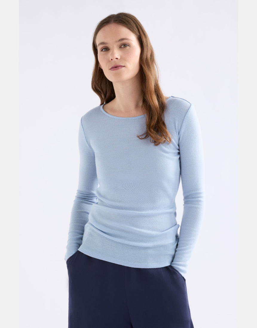 Elk Merino long sleeve top in pearl blue, lightweight, soft wool clothing with a fitted design, displayed on a hanger.