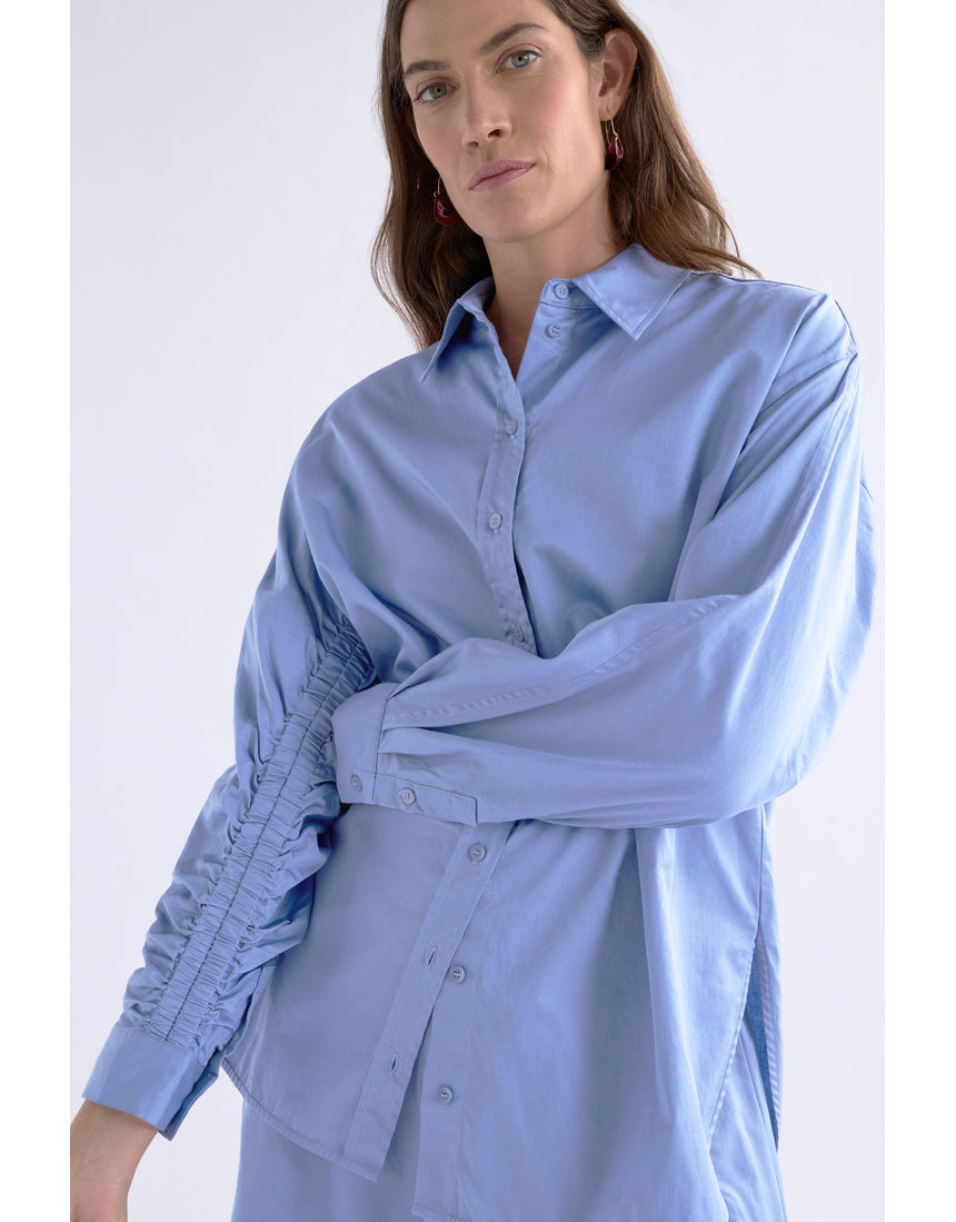 Dusk blue Elk Sol Shirt from ELK The Label, a stylish women's top with a relaxed fit and soft fabric, shown on a hanger.