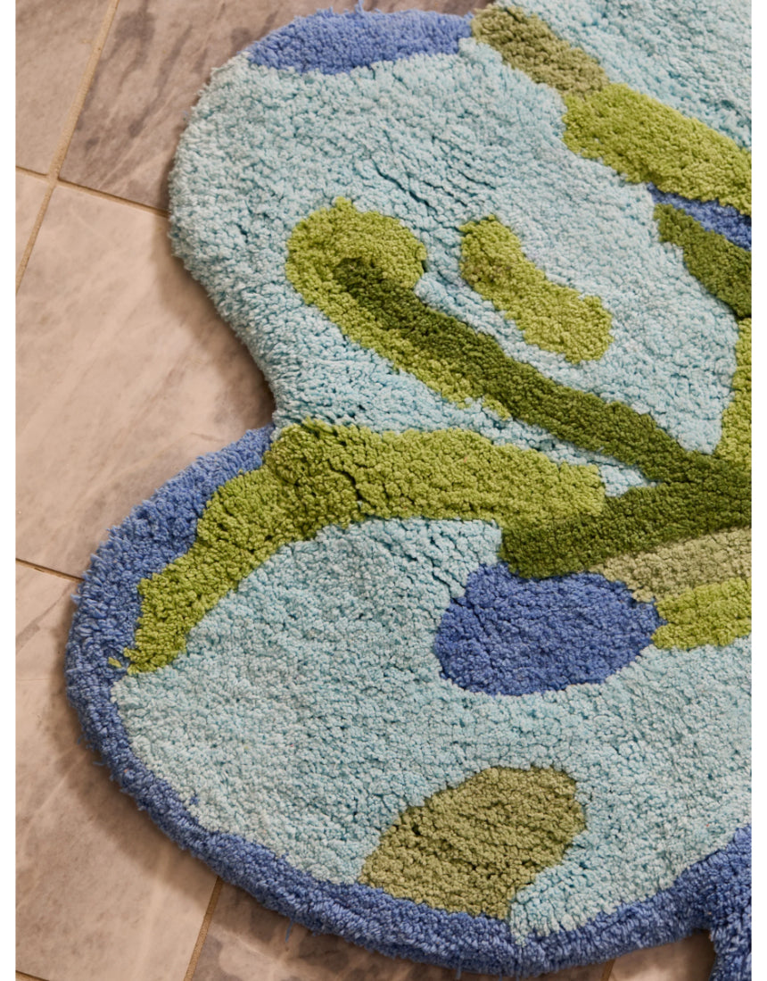Bonnie and Neil Tulip Blue Green bath mat with floral pattern, soft fabric, and non-slip backing for bathroom decor.