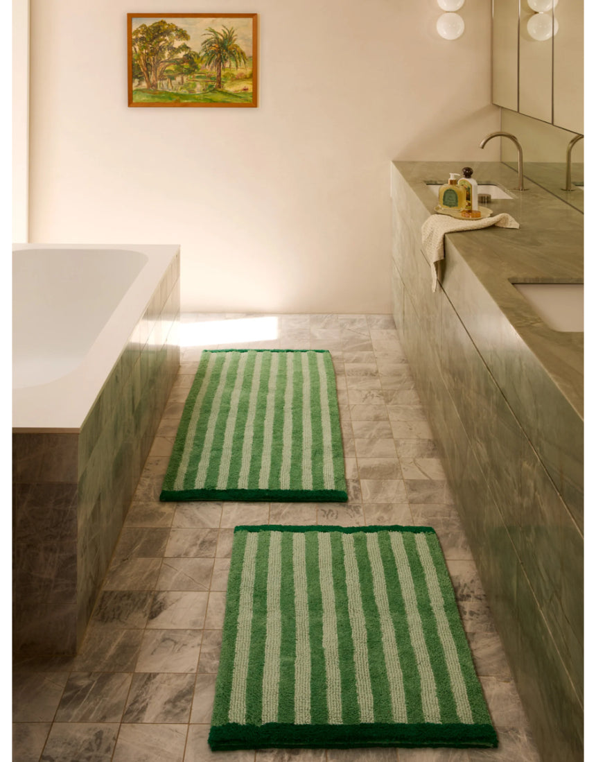 Reversible green bath mat with stripe pattern by Bonnie and Neil, displayed in a bathroom setting.