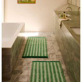 Reversible green bath mat with stripe pattern by Bonnie and Neil, displayed in a bathroom setting.