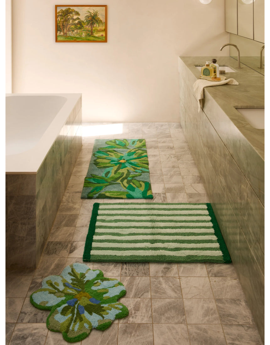 Reversible green striped bath mat by Bonnie and Neil, styled in a bathroom setting with soft textures and modern design.