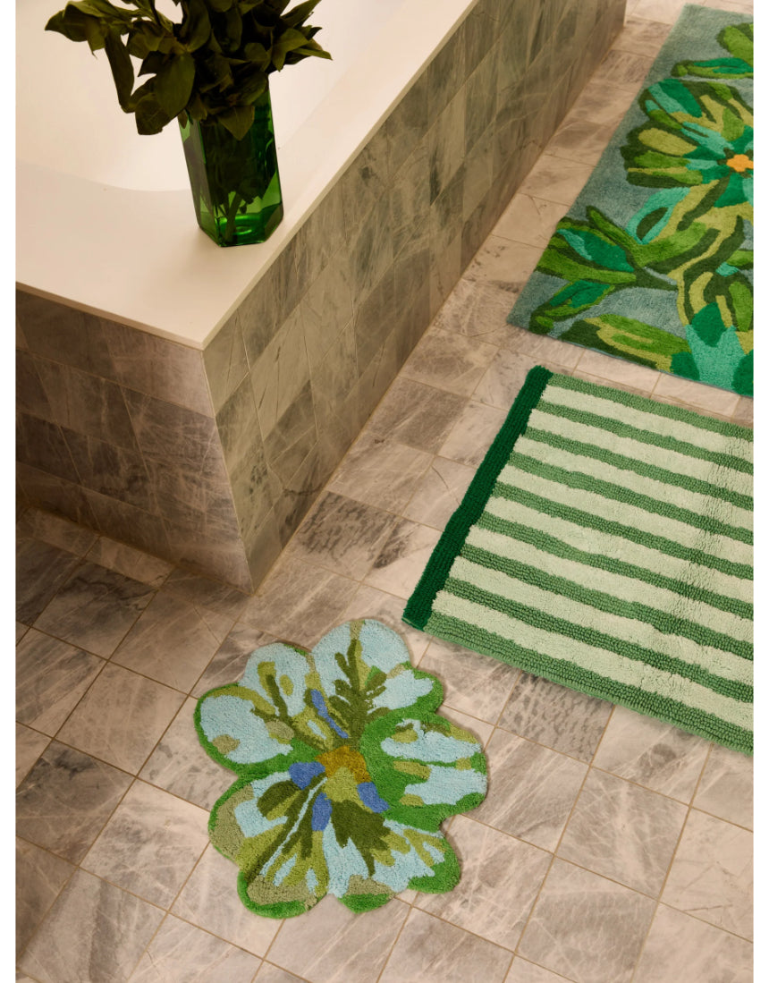 Reversible green bath mat with white stripe pattern from Bonnie and Neil, styled in a modern bathroom setting.