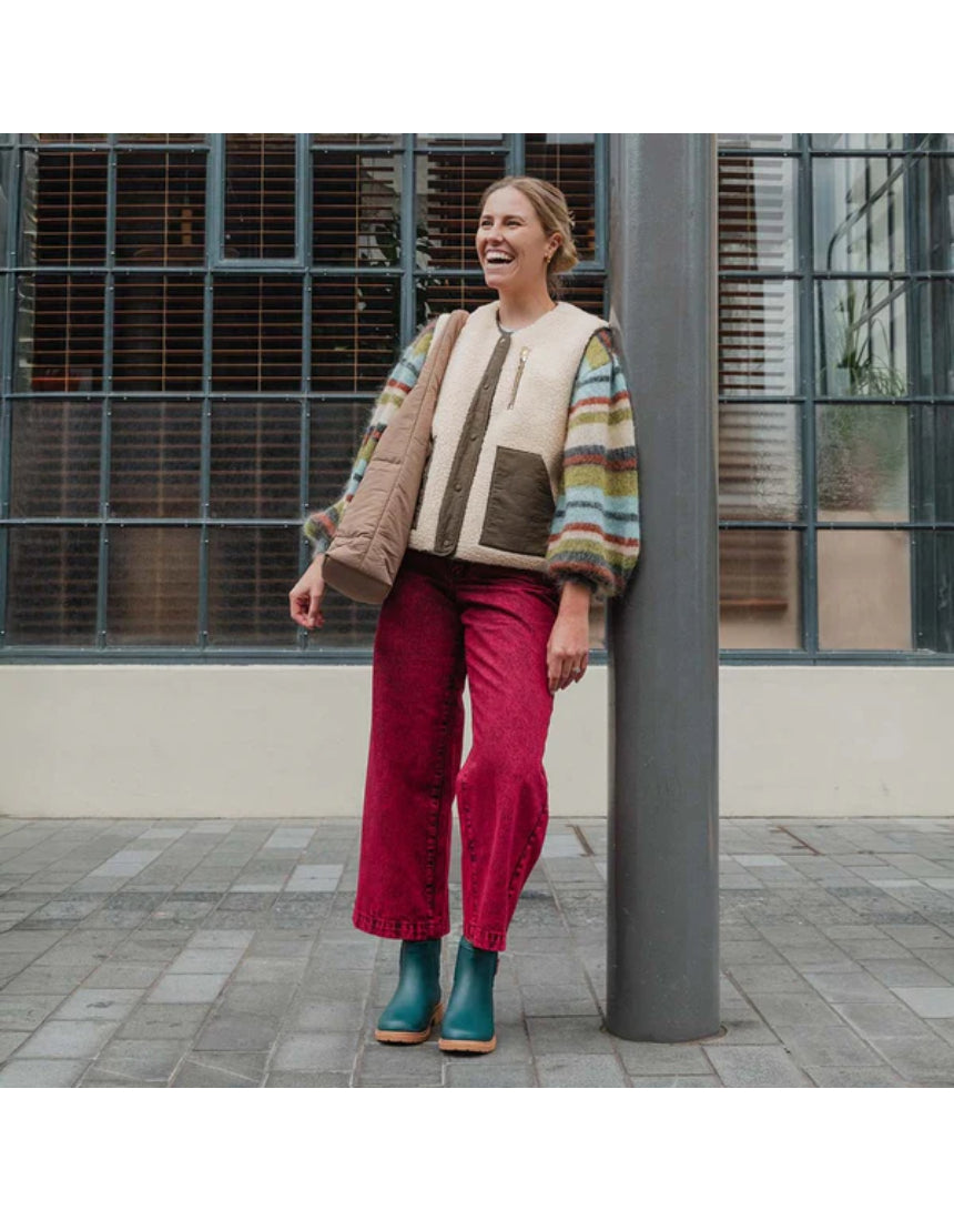 Teal Merry People Bobbi gumboots displayed outdoors, featuring waterproof rubber material and stylish design for rainy days.
