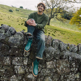 Merry People Bobbi Gumboots in teal, stylish waterproof rain boots for women, shown in a lifestyle outdoor scene.