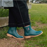 Merry People Bobbi Gumboots in teal, stylish waterproof rain boots for women, shown outdoors with greenery background