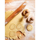 Suck UK customizable cookie stamp with engraved design, showing the stamp pressed onto freshly baked cookies.