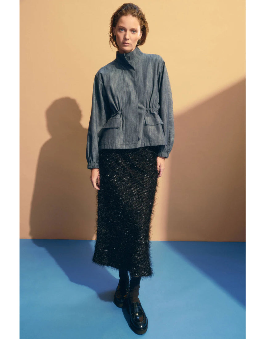 Elk Ilta skirt in neutral fabric, featuring a high waist and flowing design, shown on a hanger against a plain background.