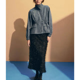 Elk Ilta skirt in neutral fabric, featuring a high waist and flowing design, shown on a hanger against a plain background.