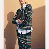 Elk Svea Organic Knit Sweater in natural beige, featuring a cozy, textured knit pattern and ribbed cuffs on a casual clothing model.