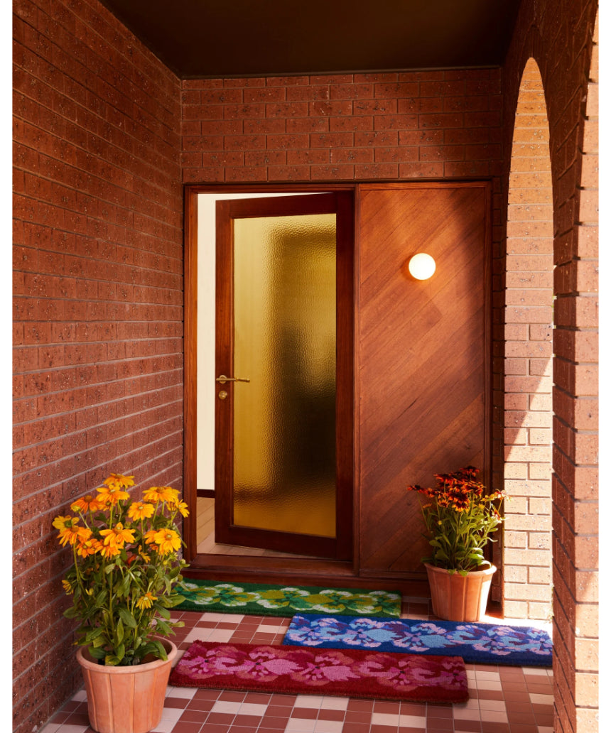 Pink coir door mat featuring a pansy flower design by Bonnie and Neil, ideal for welcoming entryways.