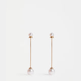 Gold Elk Sarra Drop Earring featuring a sleek, curved design with a polished finish, hanging elegantly against a plain background.