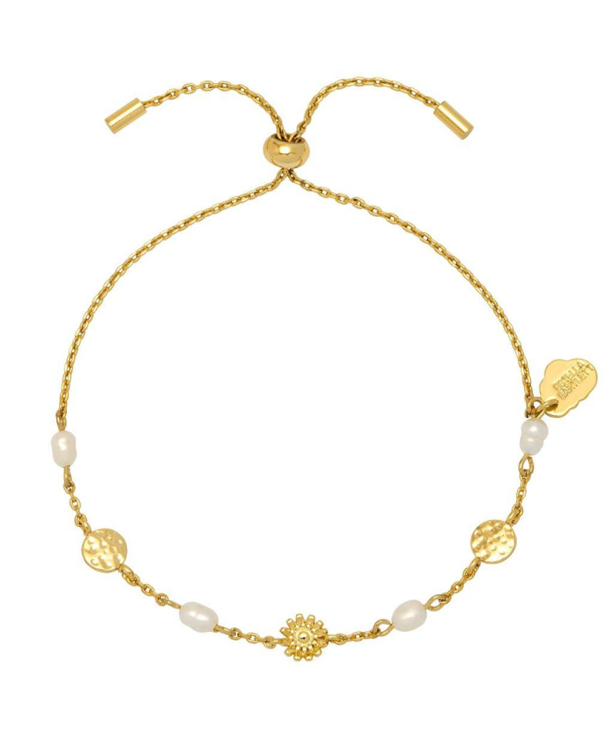 Estella Bartlett flower pearl hammered disc bracelet with delicate chain and floral charm on a jewelry display.