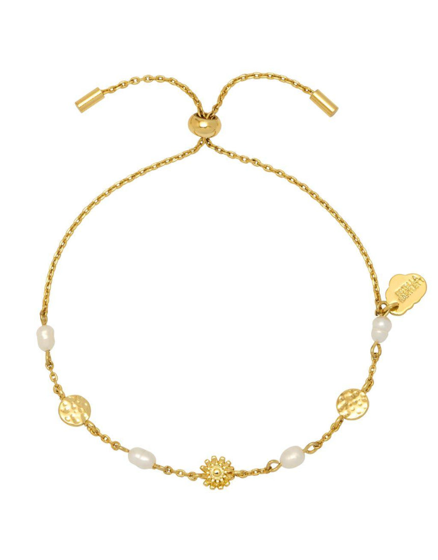 Estella Bartlett flower pearl hammered disc bracelet with delicate chain and floral charm on a jewelry display.