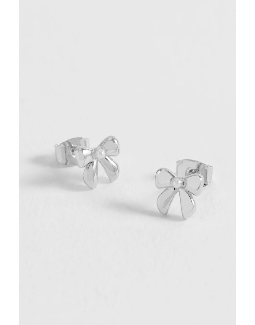 Silver Estella Bartlett pearl bow stud earrings with delicate design and shiny finish, featuring elegant pearl accents.