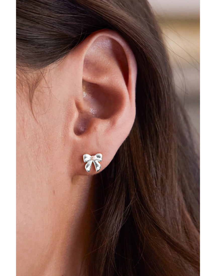 Silver pearl bow stud earrings by Estella Bartlett featuring elegant pearl and bow design for a sophisticated look.