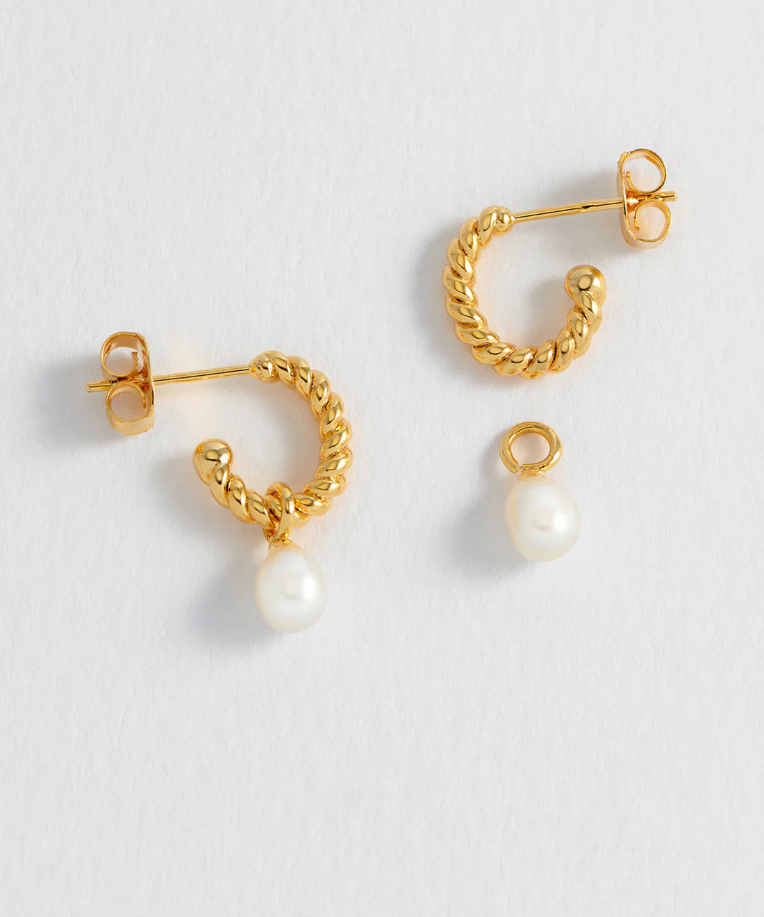 Estella Bartlett pearl drop and twist hoop earrings featuring elegant pearl accents and gold-tone hoop design.