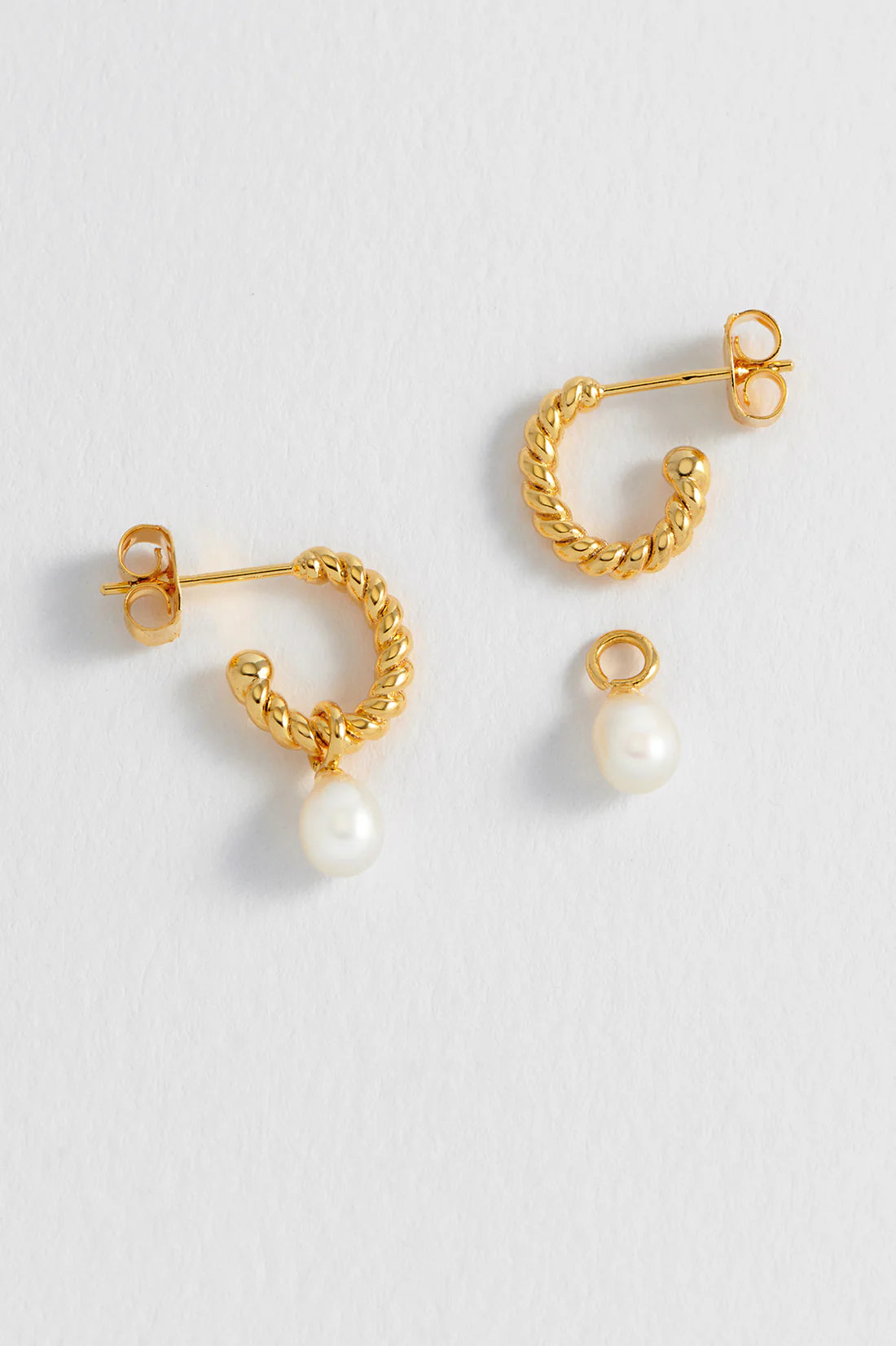Estella Bartlett pearl drop and twist hoop earrings featuring elegant pearl accents and gold-tone hoop design.