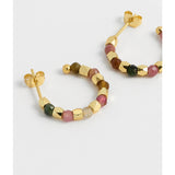 Gold hoop earrings by Estella Bartlett featuring coco and tourmaline accents, displayed on a neutral background.