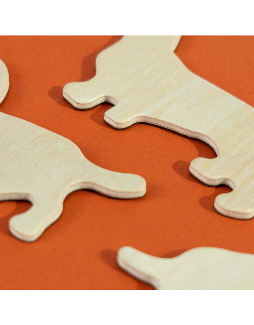 Set of Suck UK fridge magnets featuring colorful cartoon dogs with playful expressions on a metallic surface.