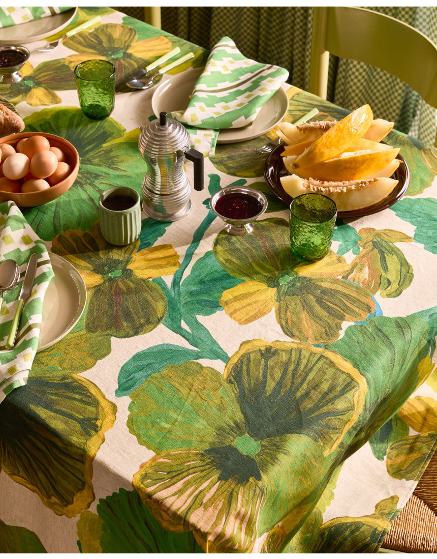 Bonnie and Neil Gem Green glass tumbler with a smooth, rounded shape, displayed on a dining table setting.
