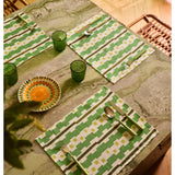 Bonnie and Neil Gem Green glass tumbler with a smooth, rounded shape, displayed on a dining room table setting.