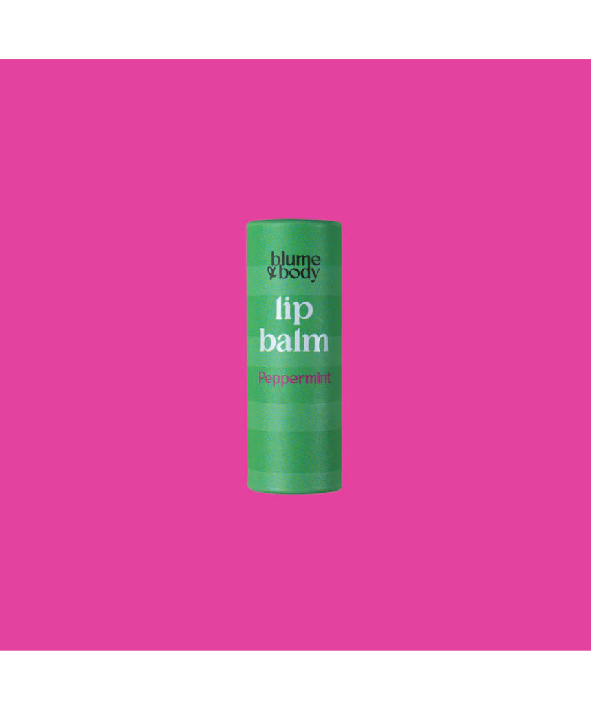 Green peppermint lip balm by Bloom & Body in a sleek container with fresh mint leaves beside it.