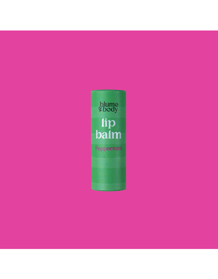 Green peppermint lip balm by Bloom & Body in a sleek container with fresh mint leaves beside it.