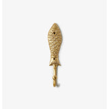 Brass fish-shaped wall hook by Bonnie and Neil mounted on a wall, featuring a sleek, decorative design for hanging items.
