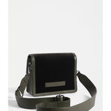 Dark olive ELK The Label Vel crossbody bag with adjustable strap and sleek design, shown hanging with a subtle texture.