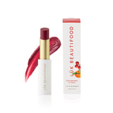 Luk Beautifood Lip Nourish cranberry citrus lipstick in a sleek tube with vibrant red and orange shades.