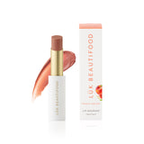 Luk Beautifood Lip Nourish lipstick in Peach Melon, showing a smooth, natural lipstick tube with peach-orange shade.