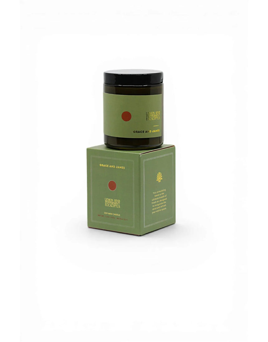 Grace & James Forager Candle with lemon rind, peppermint, and eucalyptus showing a white candle in a glass jar with fresh herbs
