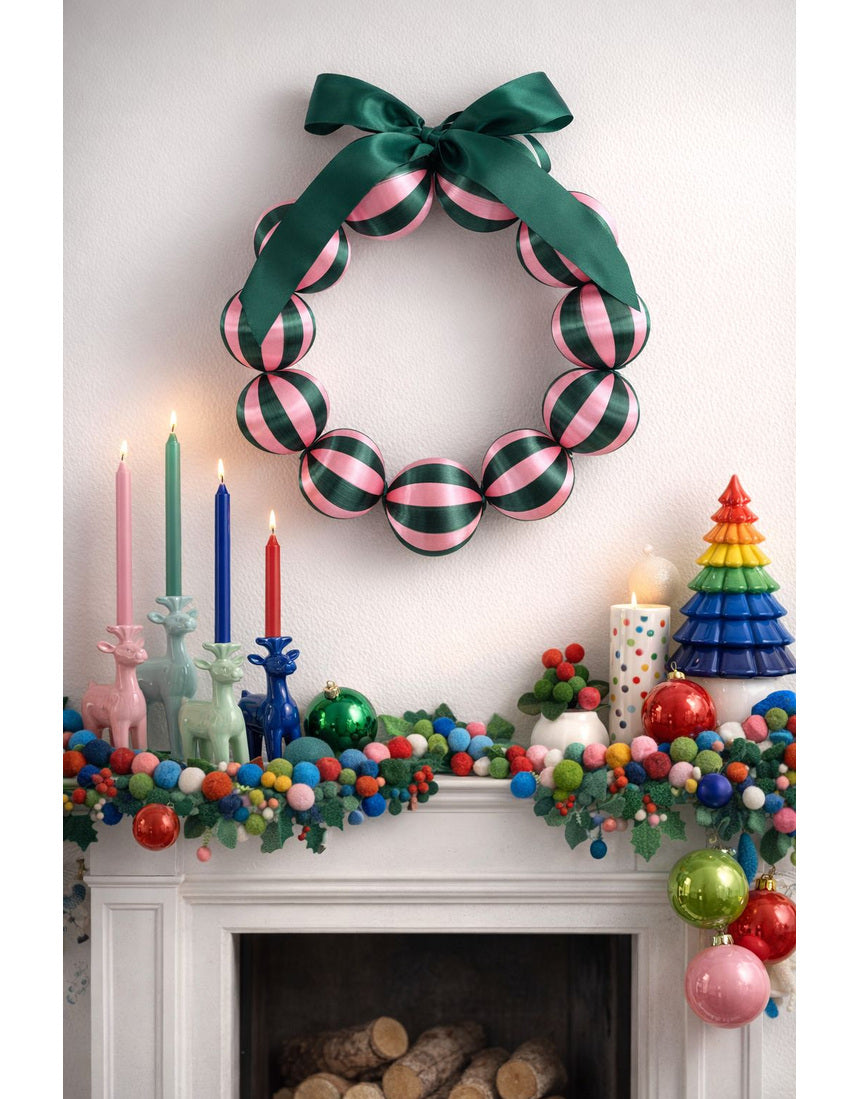 Little Fish Co silk ball Christmas wreath with green and pink decorative elements hanging on a door.