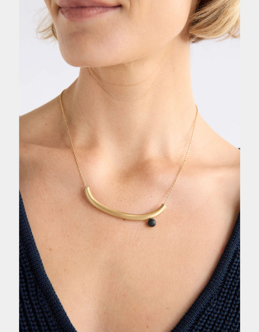 Elk gold Ahas necklace featuring a delicate chain with a small, intricate pendant, displayed against a neutral background.