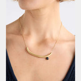 Elk gold Ahas necklace featuring a delicate chain with a small, intricate pendant, displayed against a neutral background.