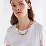 Elk Hulle Necklace in gold, featuring a delicate chain and minimalist pendant, worn around the neck.