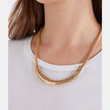 Gold Elk Hulle necklace featuring a delicate chain with a simple, elegant pendant, displayed on a neutral background.